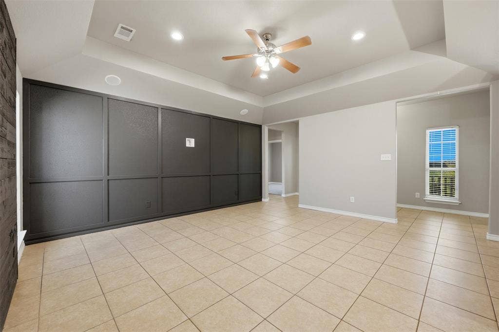 113 Mulkey Road, Waxahachie, TX 75167 bedroom with ceiling fan, a raised ceiling, recessed lighting, and light tile patterned flooring