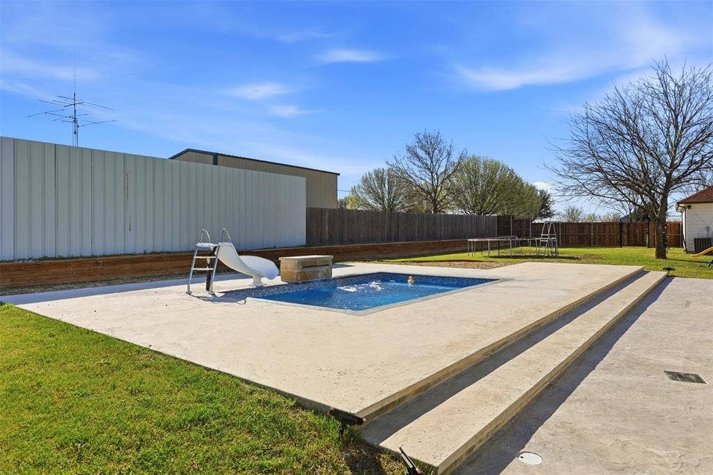 113 Mulkey Road, Waxahachie, TX 75167 View of pool with patio surround, a fenced backyard, a water slide, and a trampoline