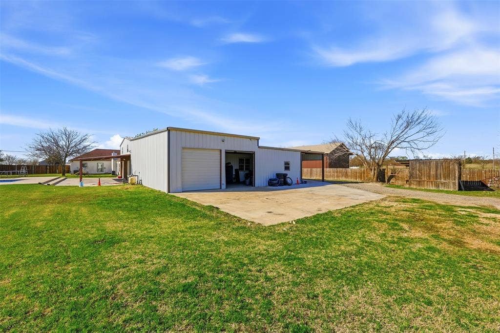 113 Mulkey Road, Waxahachie, TX 75167 Rear view of property featuring a garage, an outbuilding, and a patio area
