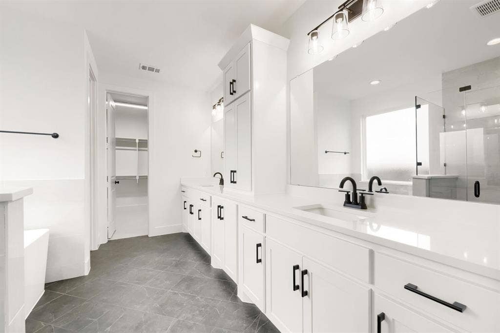 733 Red Cedar Road, Haslet, TX 76052 Spacious bathroom featuring a dual vanity with white cabinetry, matte black hardware, and an expansive mirror