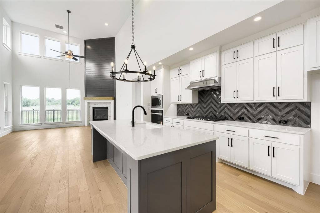 733 Red Cedar Road, Haslet, TX 76052 Open-concept living space featuring a modern kitchen island with a white countertop and dark cabinetry