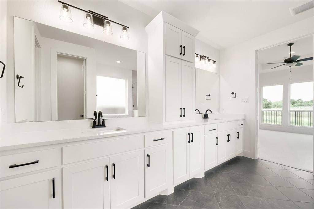 733 Red Cedar Road, Haslet, TX 76052 Dual vanity with white cabinetry, matte black hardware, and quartz countertops