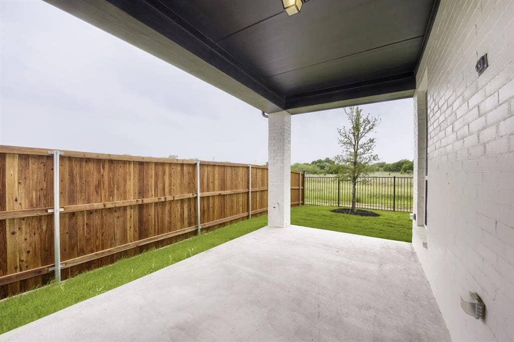 733 Red Cedar Road, Haslet, TX 76052 Covered patio with a concrete surface, white painted brick exterior, and a dark soffit