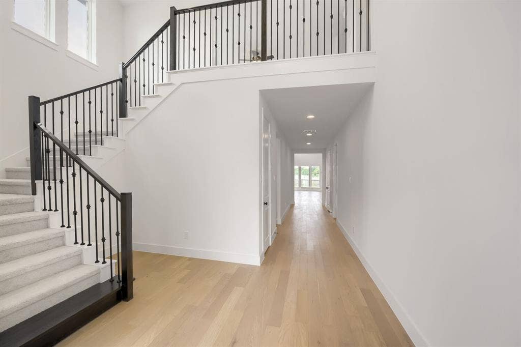 733 Red Cedar Road, Haslet, TX 76052 Two-story entryway with a carpeted staircase featuring black wrought iron balusters and wood newel posts