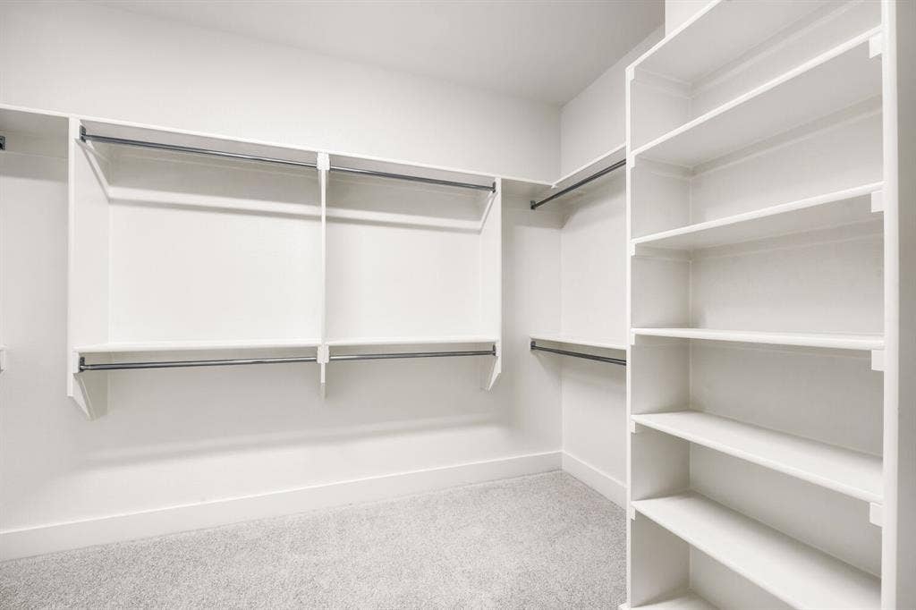 733 Red Cedar Road, Haslet, TX 76052 Walk-in closet featuring white built-in shelving, multiple hanging rods, and light gray carpet