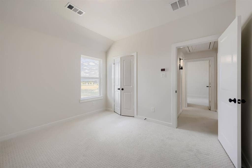 1241 Greenbriar Avenue, Haslet, TX 76052 Light-filled room featuring textured carpet flooring, a single window, and white interior doors with black hardware
