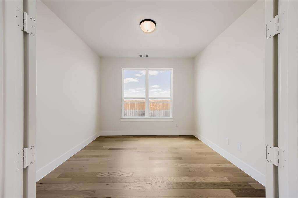 1241 Greenbriar Avenue, Haslet, TX 76052 Well-lit room featuring wood-finish flooring, white baseboards, and a single window with a white frame