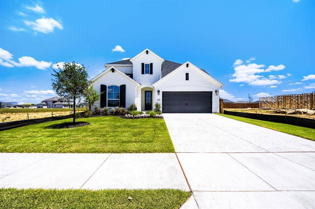 1241 Greenbriar Avenue, Haslet, TX 76052 White stucco exterior with black framed windows, a dark shingle roof, and a two-car garage