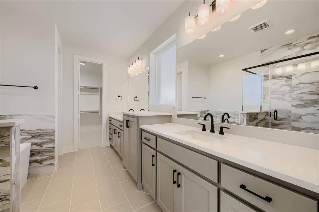 1241 Greenbriar Avenue, Haslet, TX 76052 Bathroom featuring dual vanities with white countertops, matte black fixtures, and light grey cabinetry