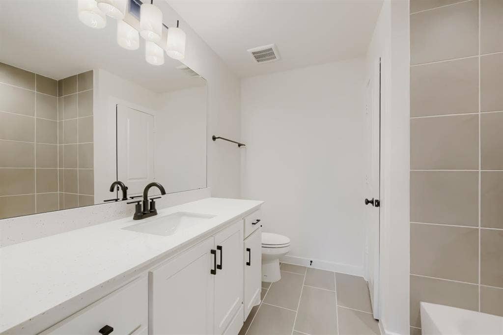 1241 Greenbriar Avenue, Haslet, TX 76052 Bathroom vanity featuring white cabinetry with dark hardware, a white countertop, and an integrated sink with a dark faucet