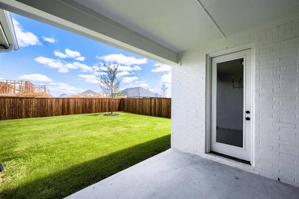 1241 Greenbriar Avenue, Haslet, TX 76052 Covered patio with a concrete slab, white painted brick exterior, and a full-light glass door
