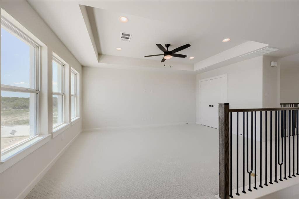1241 Greenbriar Avenue, Haslet, TX 76052 Room featuring a tray ceiling with recessed lighting, a ceiling fan, and light-colored carpeting