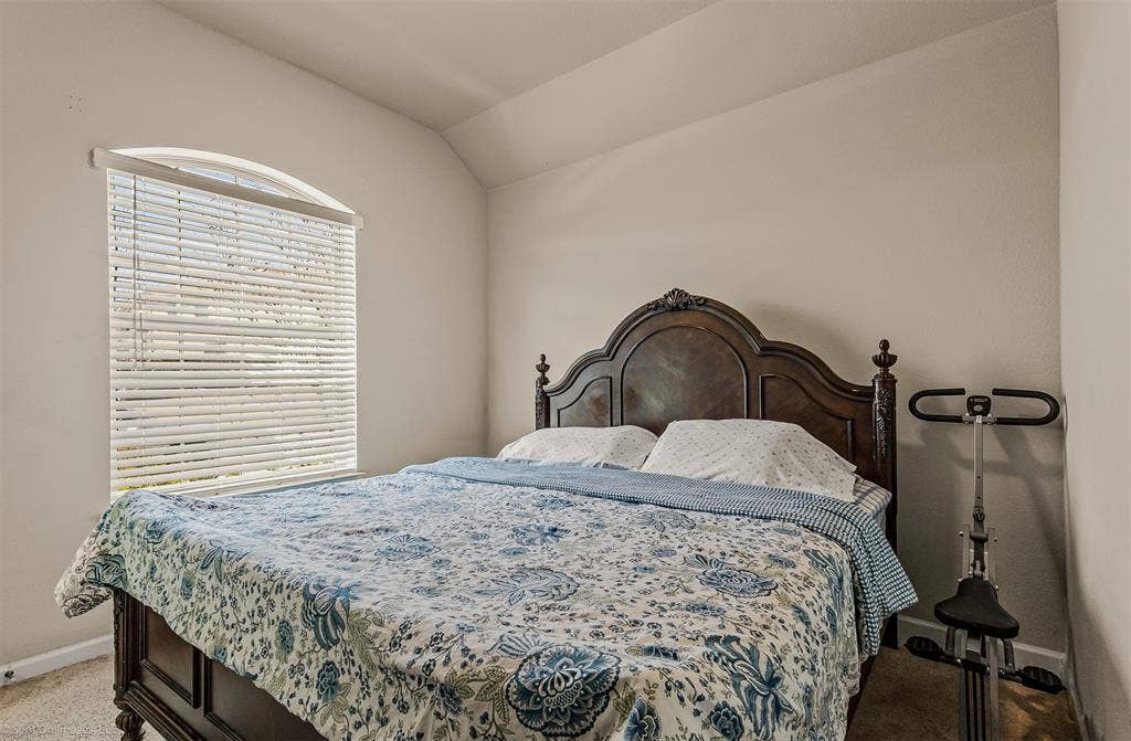 5408 Wedge Wood Drive, Haltom City, TX 76137 Carpeted bedroom featuring baseboards and lofted ceiling