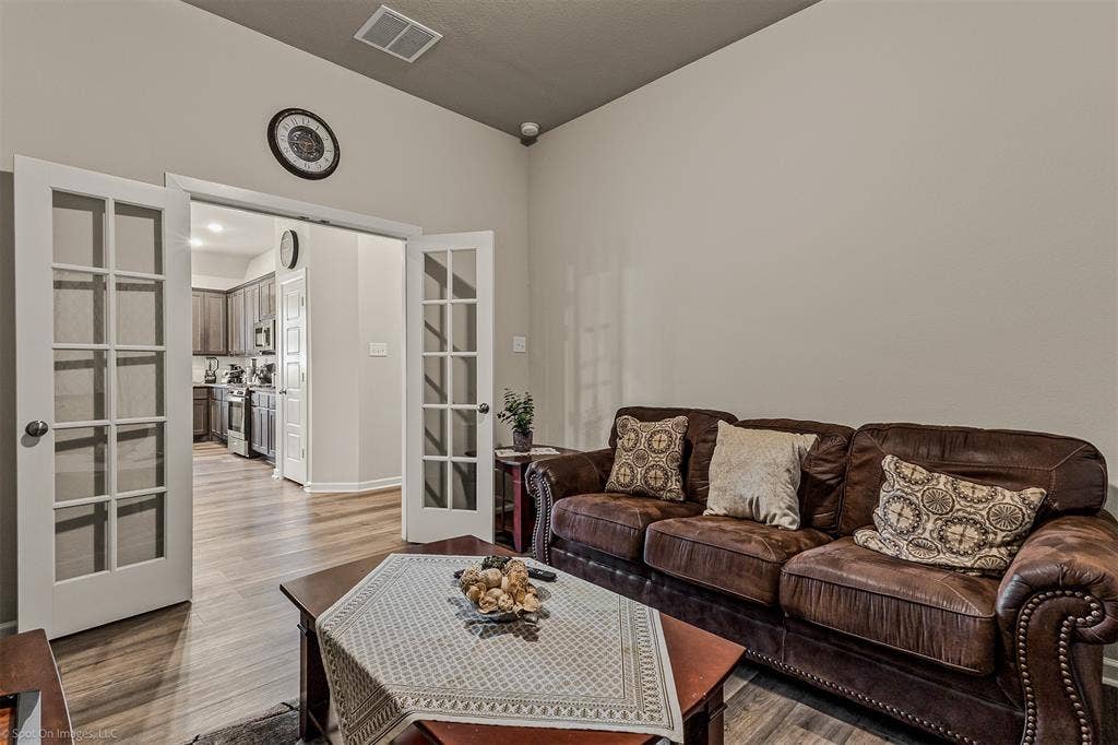 5408 Wedge Wood Drive, Haltom City, TX 76137 Second living area featuring french doors and light wood-style flooring