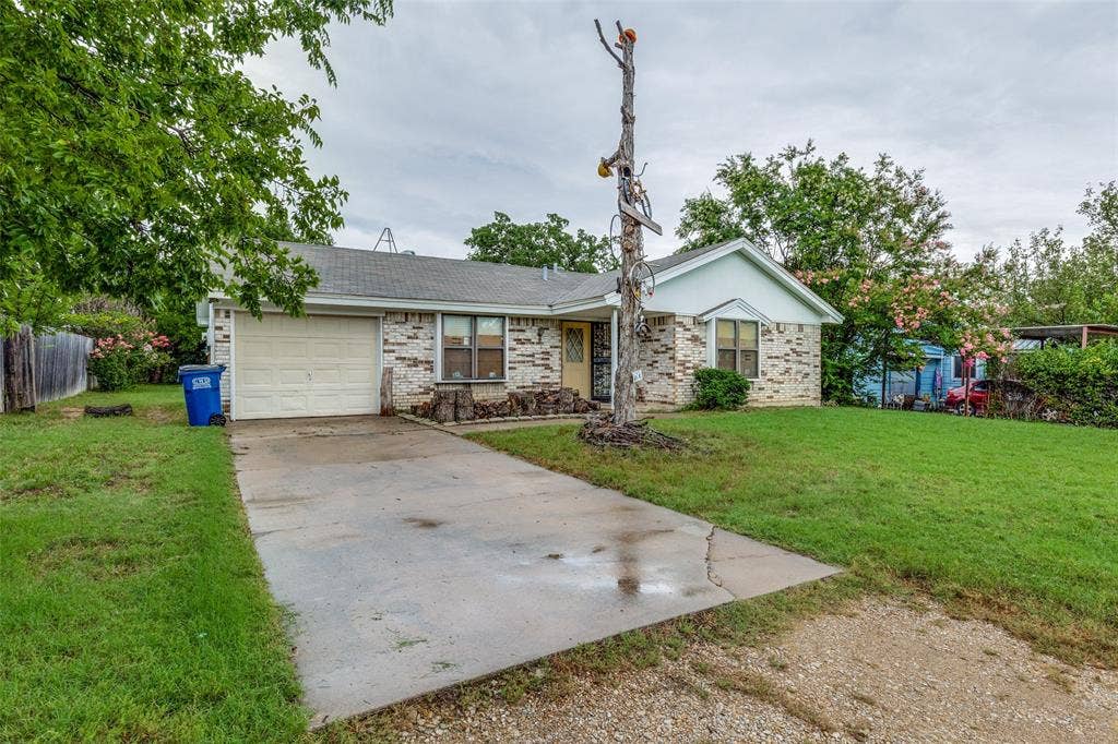Ranch-style house with concrete driveway, a garage, and brick siding