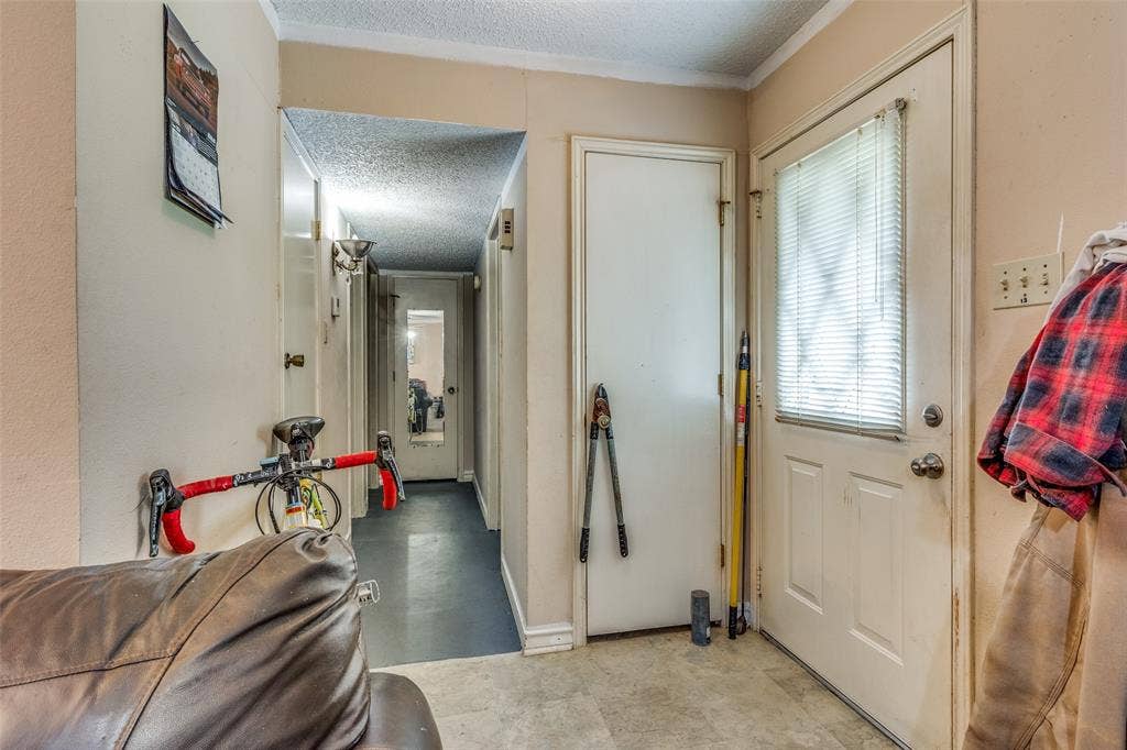 Entryway featuring a textured ceiling and baseboards