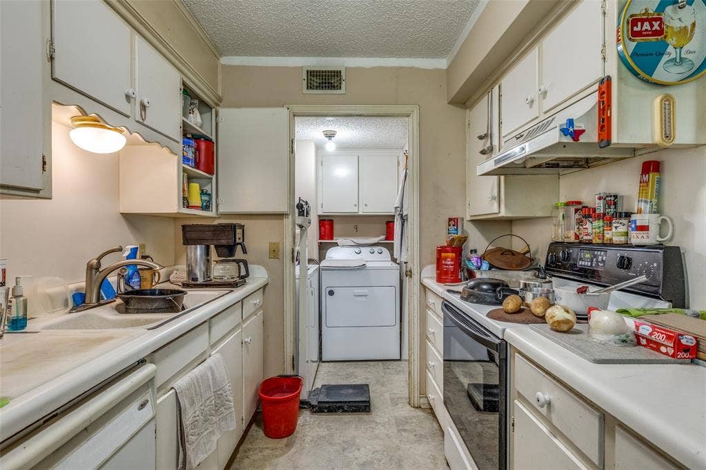 Kitchen with black electric range oven, white dishwasher, a textured ceiling, light countertops, and white cabinets