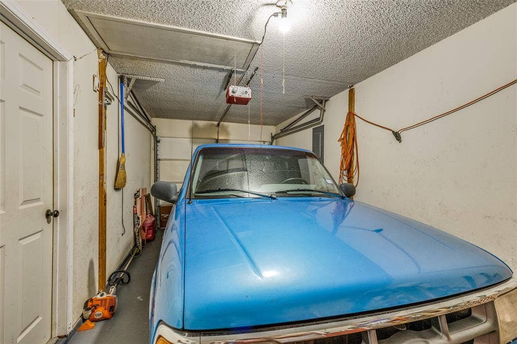 Garage featuring a garage door opener and electric panel