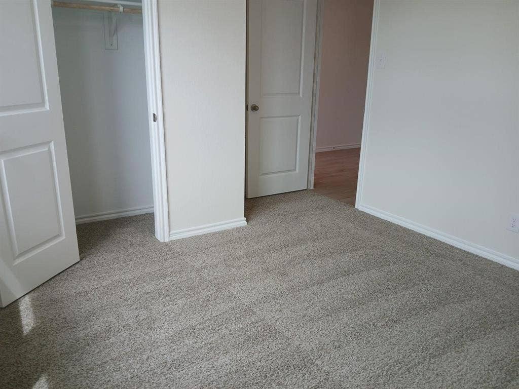 315 Whispering Pine Drive, Royse City, TX 75189 Neutral-toned carpeting extends throughout this interior space, featuring white baseboards and trim