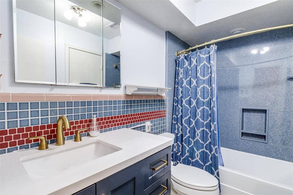 14810 Knollview Drive, Dallas, TX 75248 Full bath featuring vanity, shower / tub combo with curtain, tile walls, and backsplash