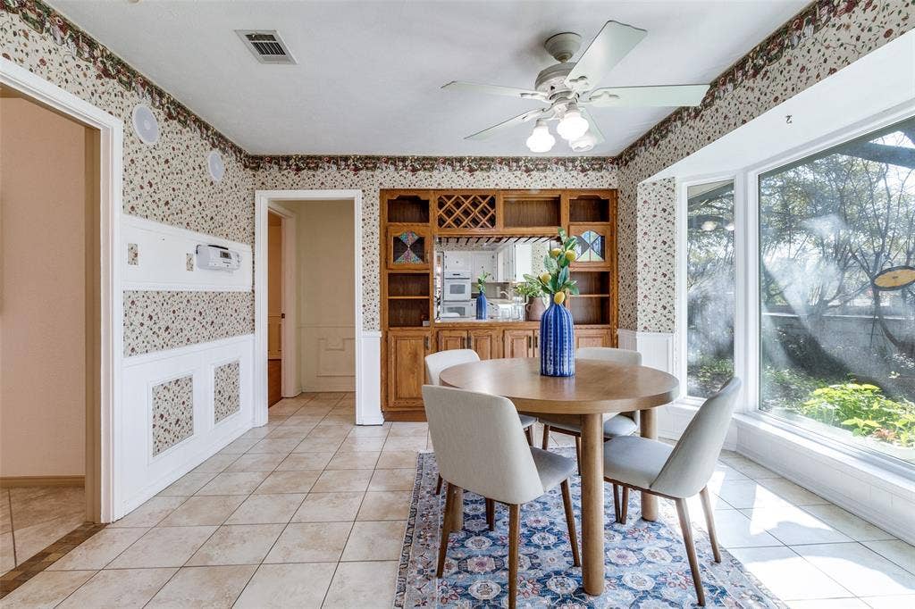 14810 Knollview Drive, Dallas, TX 75248 Dining room with a wainscoted wall, wallpapered walls, ceiling fan, and light tile patterned floors