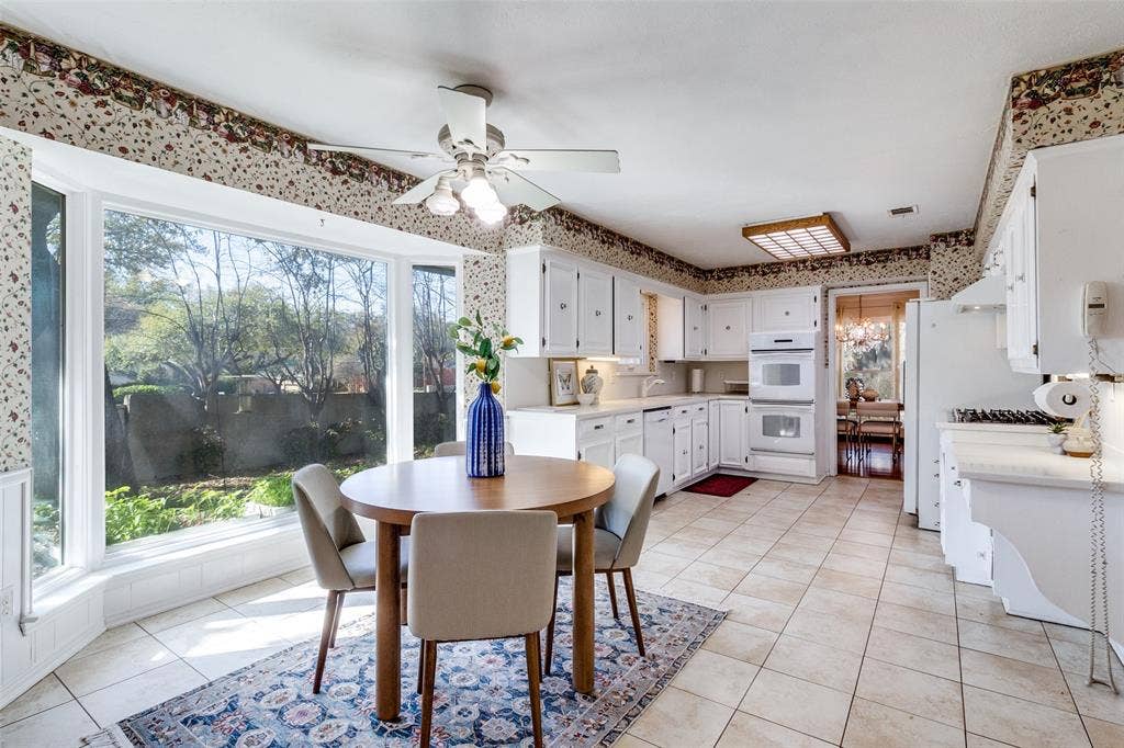 14810 Knollview Drive, Dallas, TX 75248 Dining space featuring ceiling fan, wallpapered walls, light tile patterned floors, and a chandelier