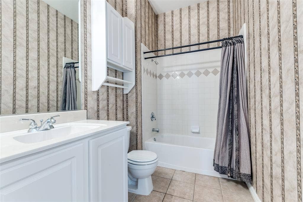 351 Southern Hills Drive, Fairview, TX 75069 Bathroom featuring wallpapered walls, vanity, shower / bathtub combination with curtain, and light tile patterned flooring