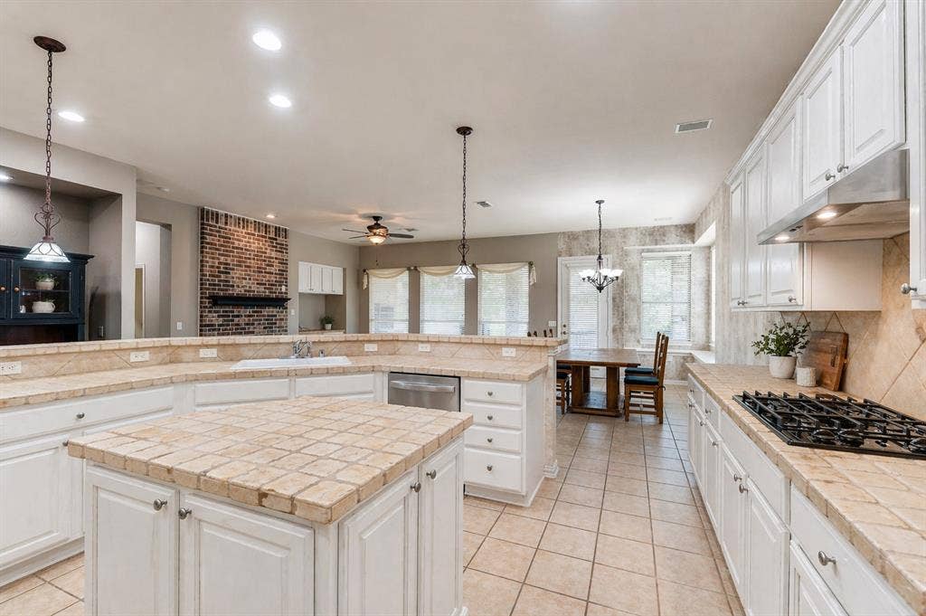 351 Southern Hills Drive, Fairview, TX 75069 Spacious kitchen featuring white cabinetry, tile countertops, a center island, a gas cooktop, and an integrated dishwasher