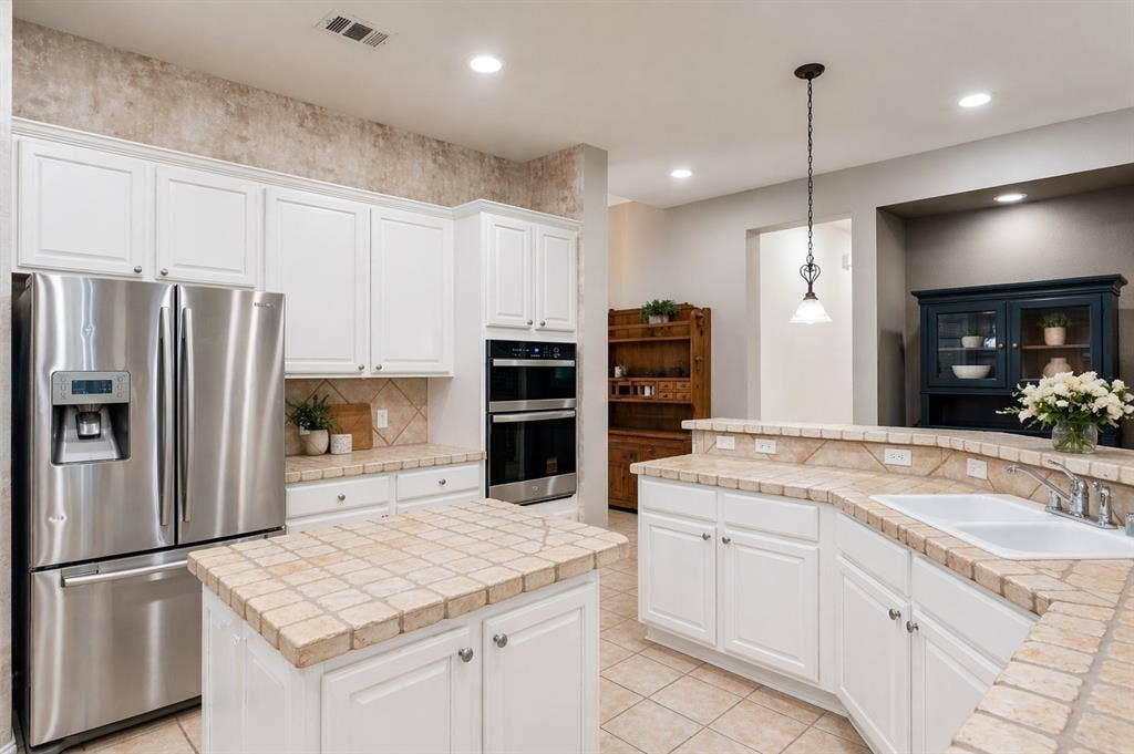 351 Southern Hills Drive, Fairview, TX 75069 Kitchen featuring white cabinetry, tile countertops, recessed lighting, stainless steel appliances, and a central island with a tiled surface