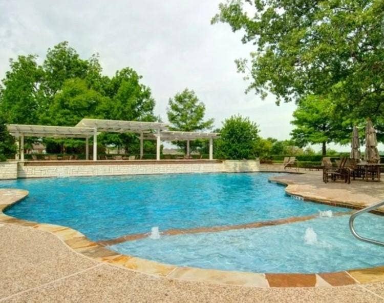 351 Southern Hills Drive, Fairview, TX 75069 Expansive pool area featuring a blue water swimming pool with integrated spa, flagstone coping, and textured concrete decking