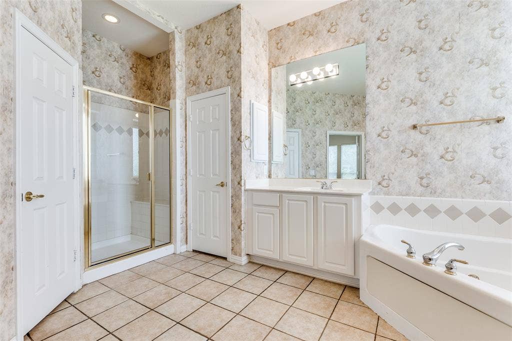 351 Southern Hills Drive, Fairview, TX 75069 Primary bath featuring a walk-in shower, vanity, a bath, and light tile patterned flooring