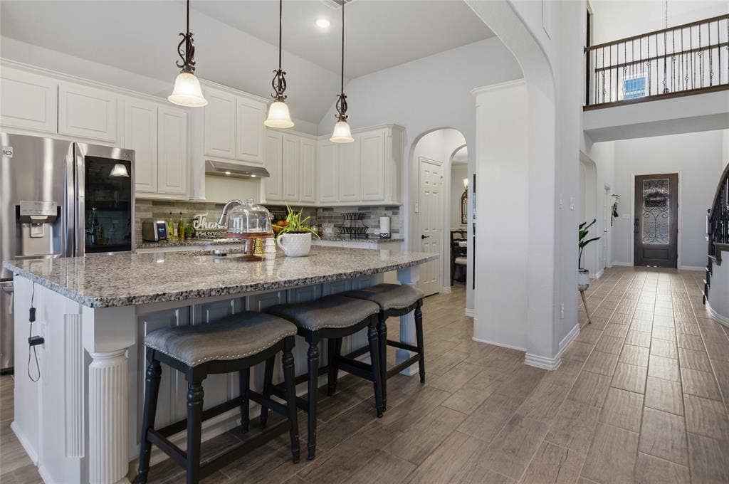 Kitchen featuring white cabinetry, granite countertops, and stainless steel appliances