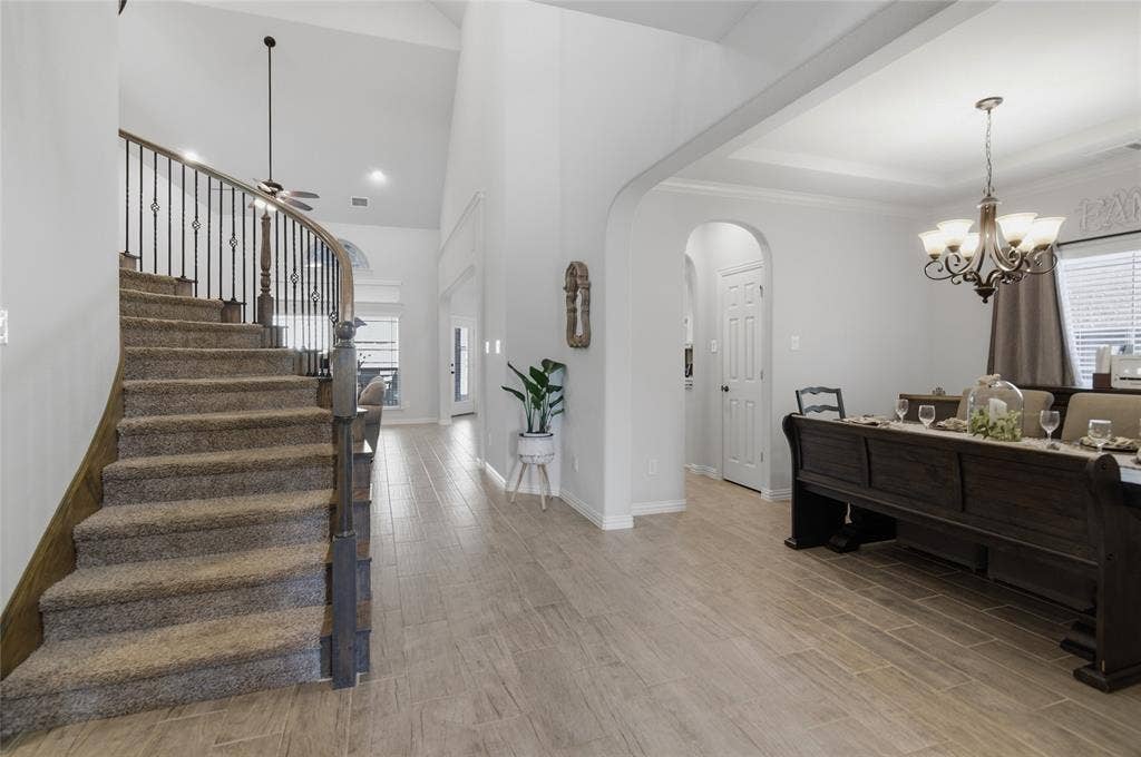 Curved staircase with iron balusters and carpeted treads