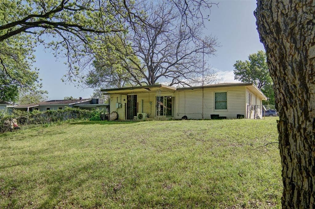 1224 S Brazos Street, Weatherford, TX 76086 Rear view of home featuring a large lawn.