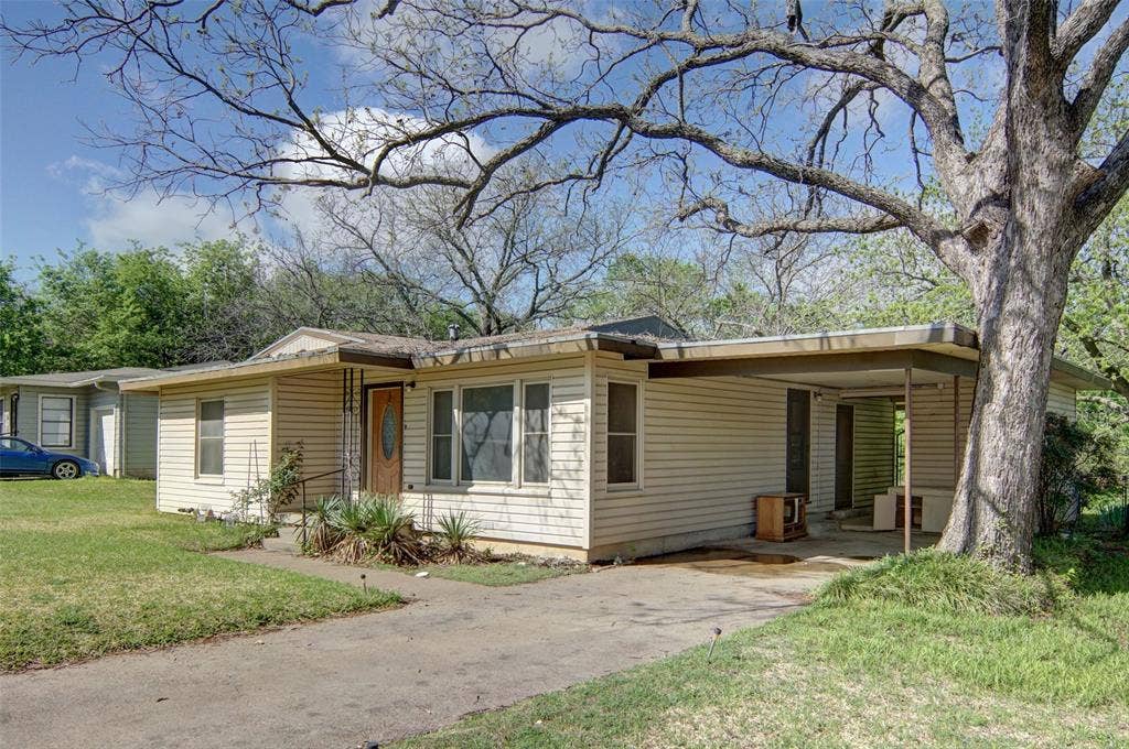 1224 S Brazos Street, Weatherford, TX 76086 View of front facade with an attached carport, a front lawn, and concrete driveway