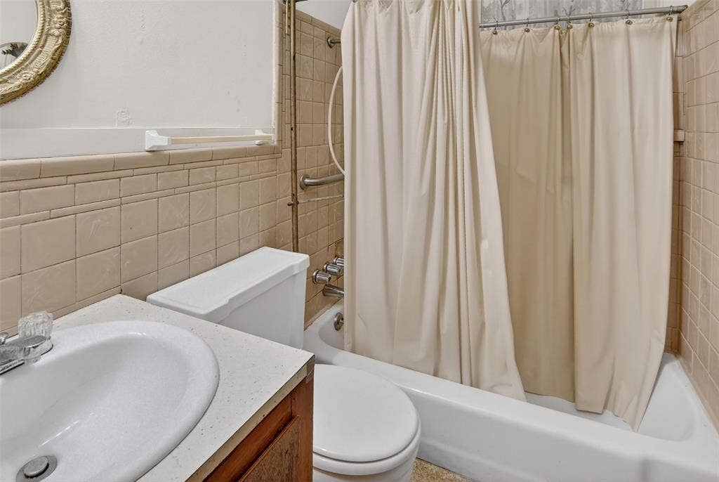 1224 S Brazos Street, Weatherford, TX 76086 Full bath #2 with shower / tub combo, vanity, and tile walls.