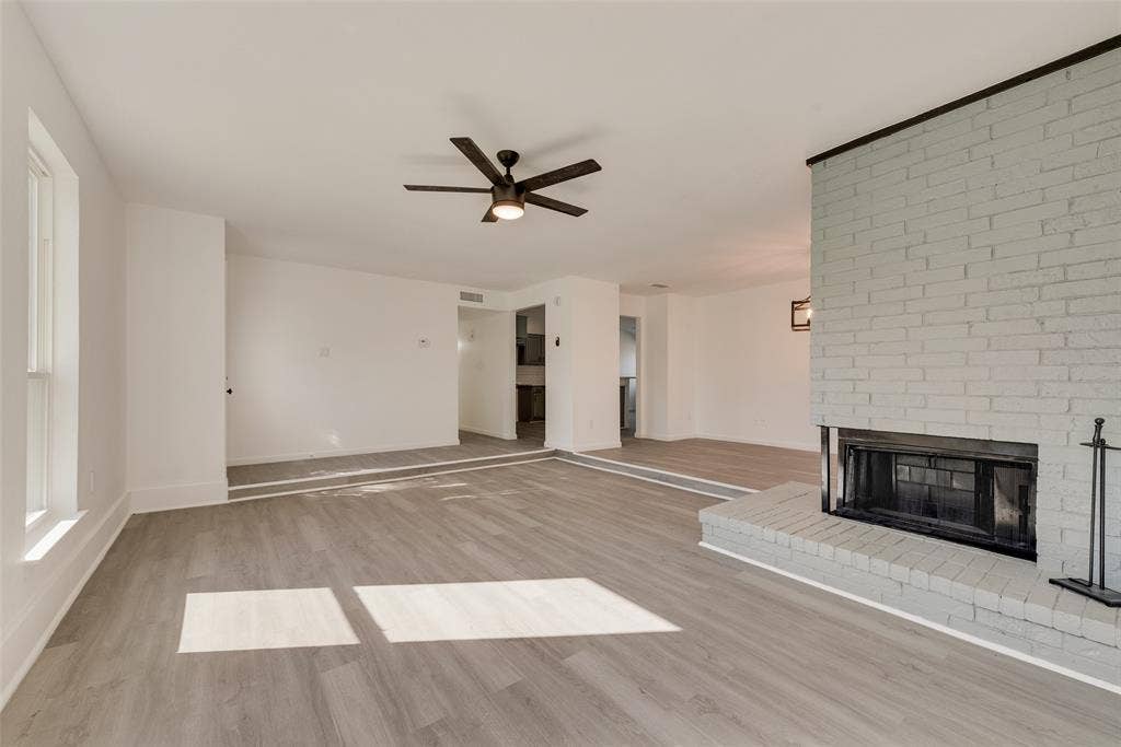 3217 Mahan Circle, Mesquite, TX 75149 Unfurnished living room with light wood finished floors, a fireplace, and a ceiling fan