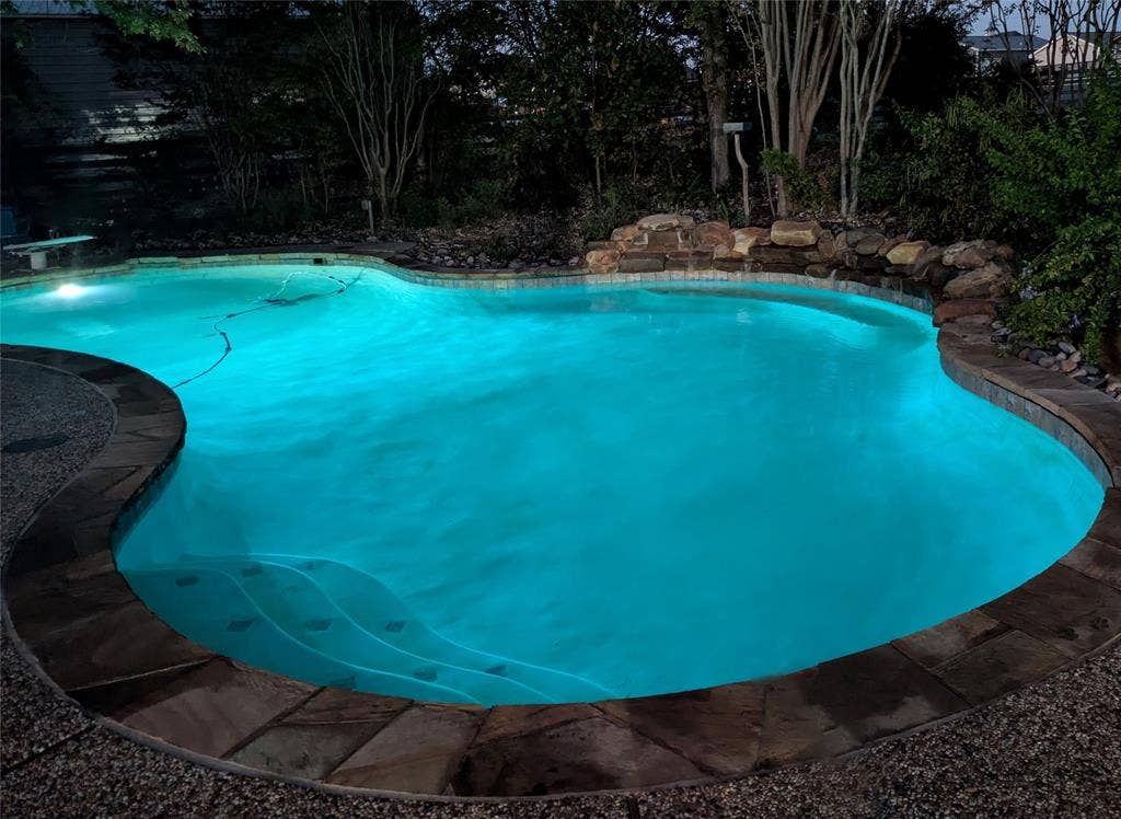 103 Collin Green Drive, Prosper, TX 75078 beautiful saltwater pool lit up at night