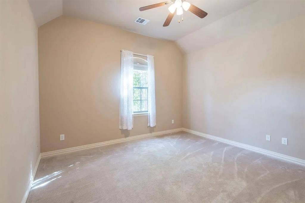 15031 Woodbluff Drive, Frisco, TX 75035 Bedroom with vaulted ceiling, neutral carpet flooring, and a window with white sheer curtains