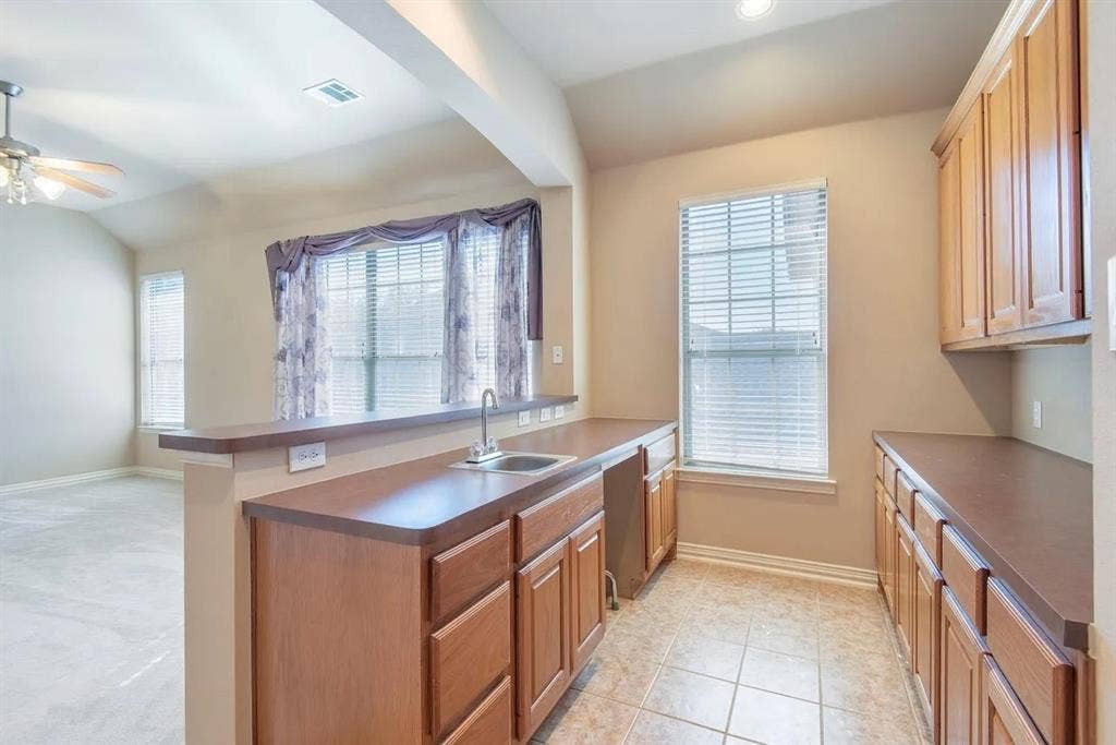 15031 Woodbluff Drive, Frisco, TX 75035 Kitchenette featuring wood-finish cabinetry, a built-in sink, and tile flooring
