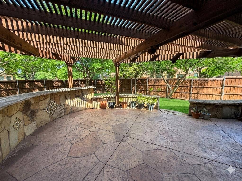 15031 Woodbluff Drive, Frisco, TX 75035 Expansive stamped concrete patio featuring a wood pergola and stone-faced built-in bar