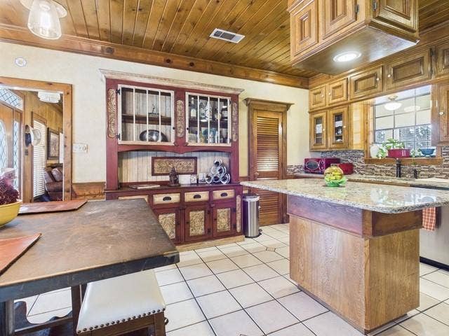 2382 Crystal Drive, Athens, TX 75752 Kitchen featuring wooden ceiling, a kitchen island, light tile patterned flooring, stainless steel dishwasher, and glass insert cabinets