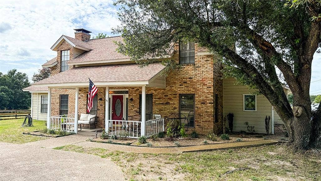 2382 Crystal Drive, Athens, TX 75752 View of front of home featuring a chimney, a shingled roof, brick siding, and a porch