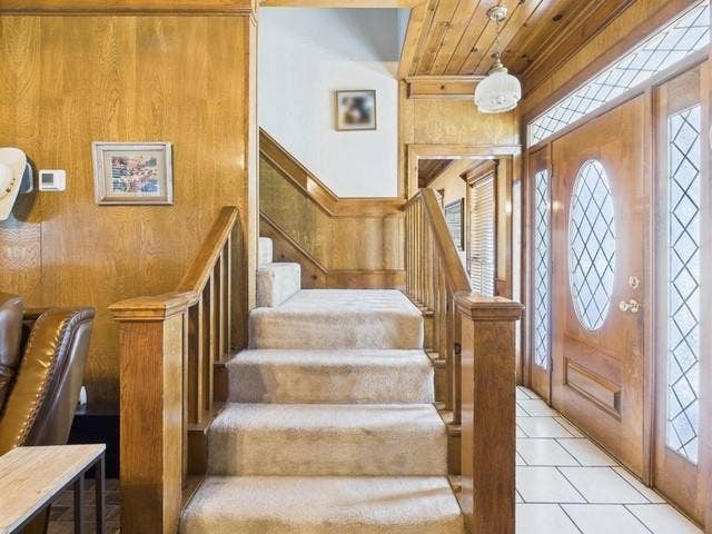 2382 Crystal Drive, Athens, TX 75752 Foyer featuring stairs, light tile patterned flooring, wood walls, and wooden ceiling