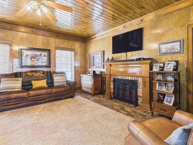 2382 Crystal Drive, Athens, TX 75752 Living area featuring wooden ceiling, crown molding, a fireplace, ceiling fan, and wood walls