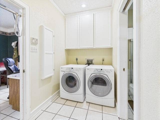2382 Crystal Drive, Athens, TX 75752 Washroom with washing machine and dryer, light tile patterned flooring, crown molding, and cabinet space