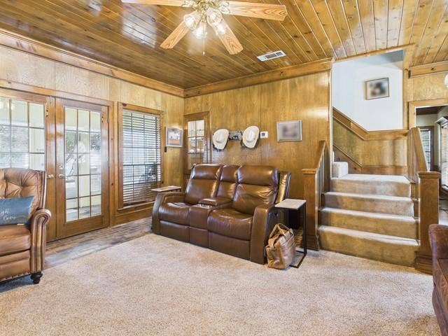 2382 Crystal Drive, Athens, TX 75752 Carpeted living area with wooden ceiling, wood walls, ceiling fan, and stairway