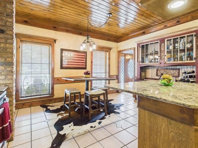 2382 Crystal Drive, Athens, TX 75752 Kitchen with light tile patterned floors, wood ceiling, decorative light fixtures, a chandelier, and glass insert cabinets
