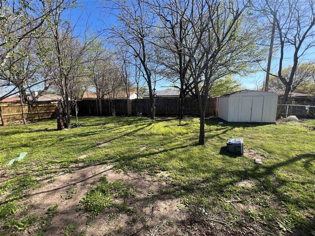 6036 Harrison Way, Watauga, TX 76148 Fenced backyard with a storage unit