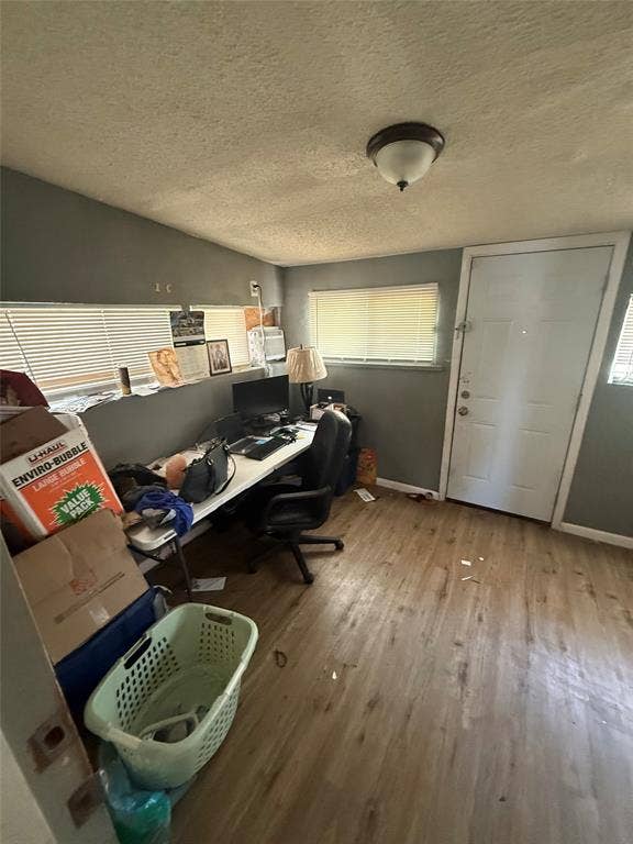 6036 Harrison Way, Watauga, TX 76148 Office space featuring a textured ceiling, light wood-type flooring, and healthy amount of natural light